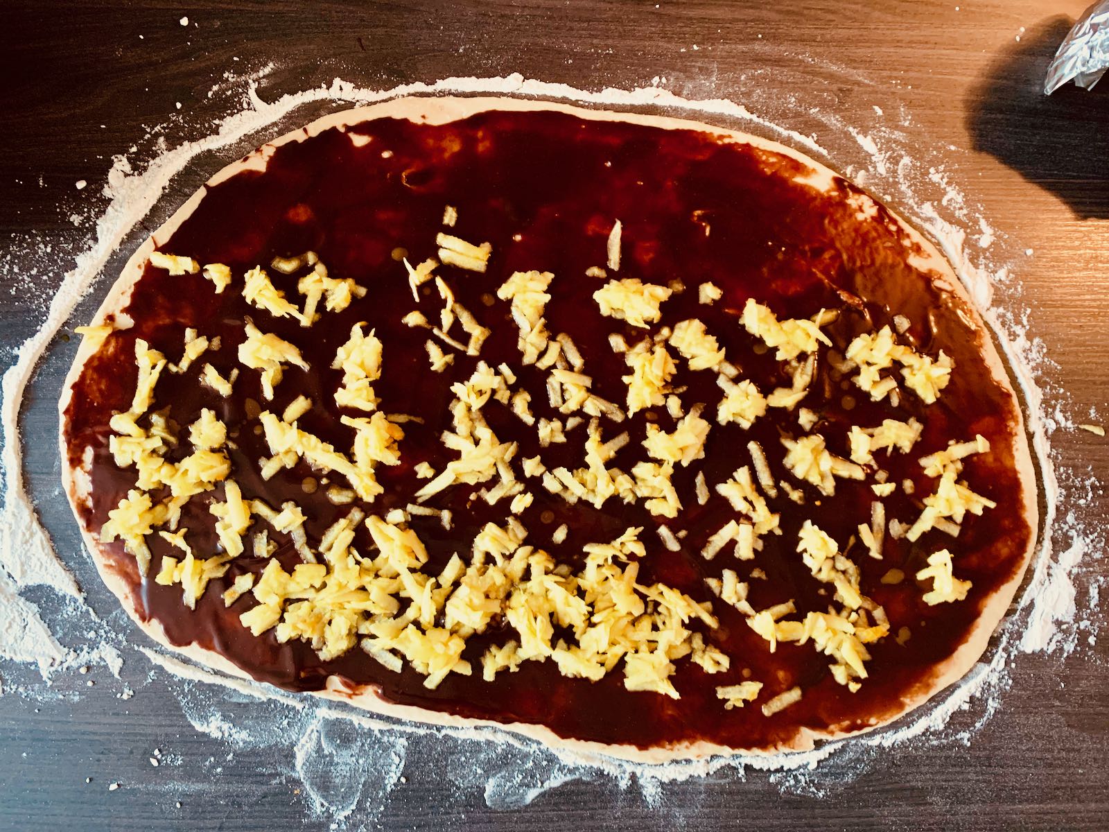 Dough rolled out with chocoltate and apple filling on top