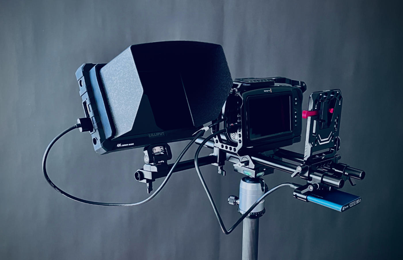 Video camera rig built with metal rods with a monitor on the side, view from the back