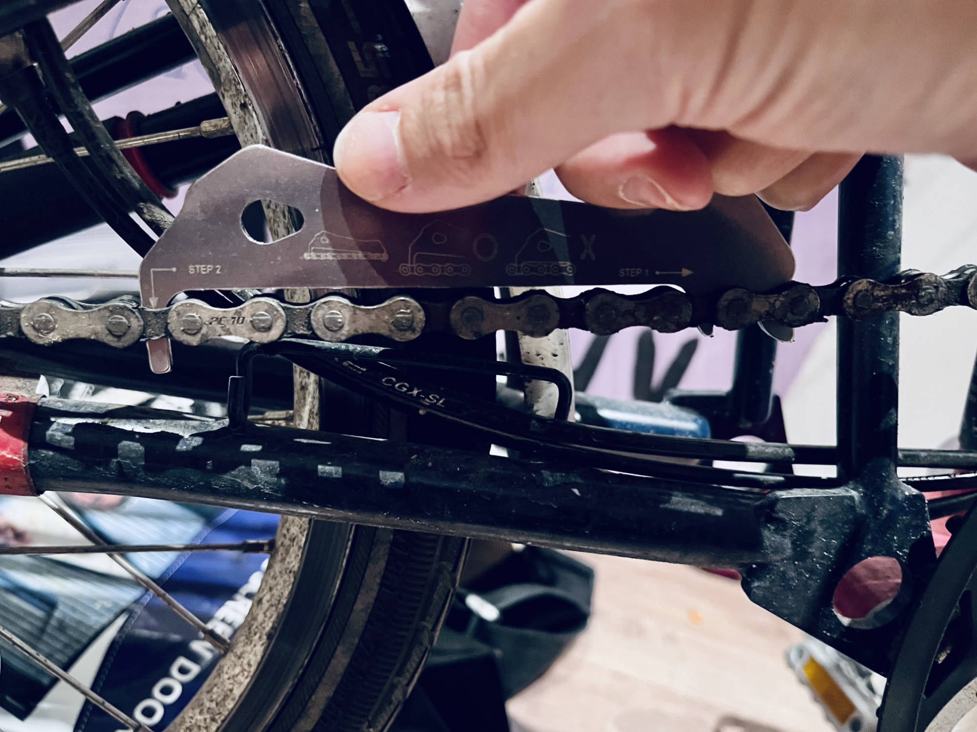 Bike chain measuring tool indicating the chain is worn out
