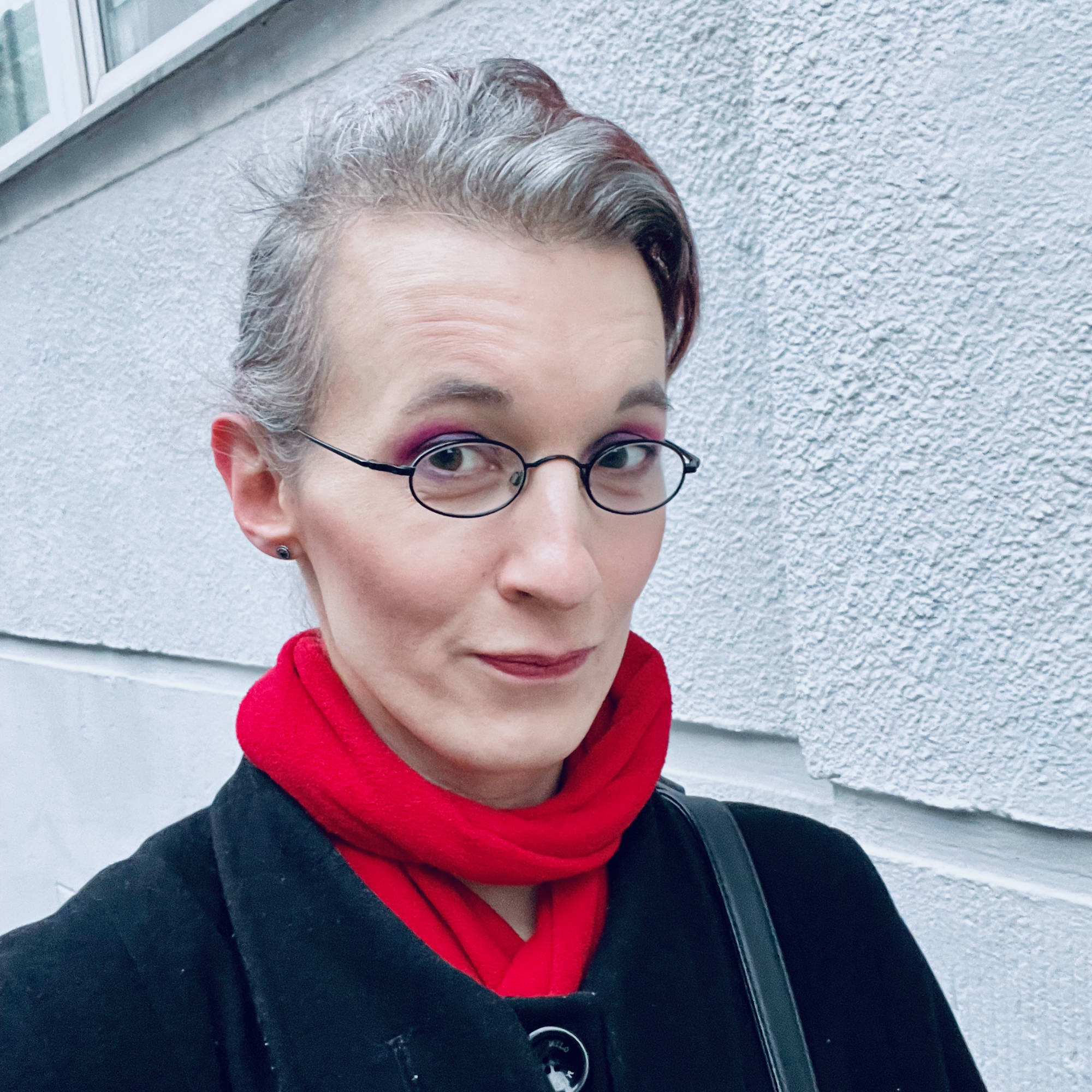 Selfie, outside, with relatively heavy make-up, wearing a black coat