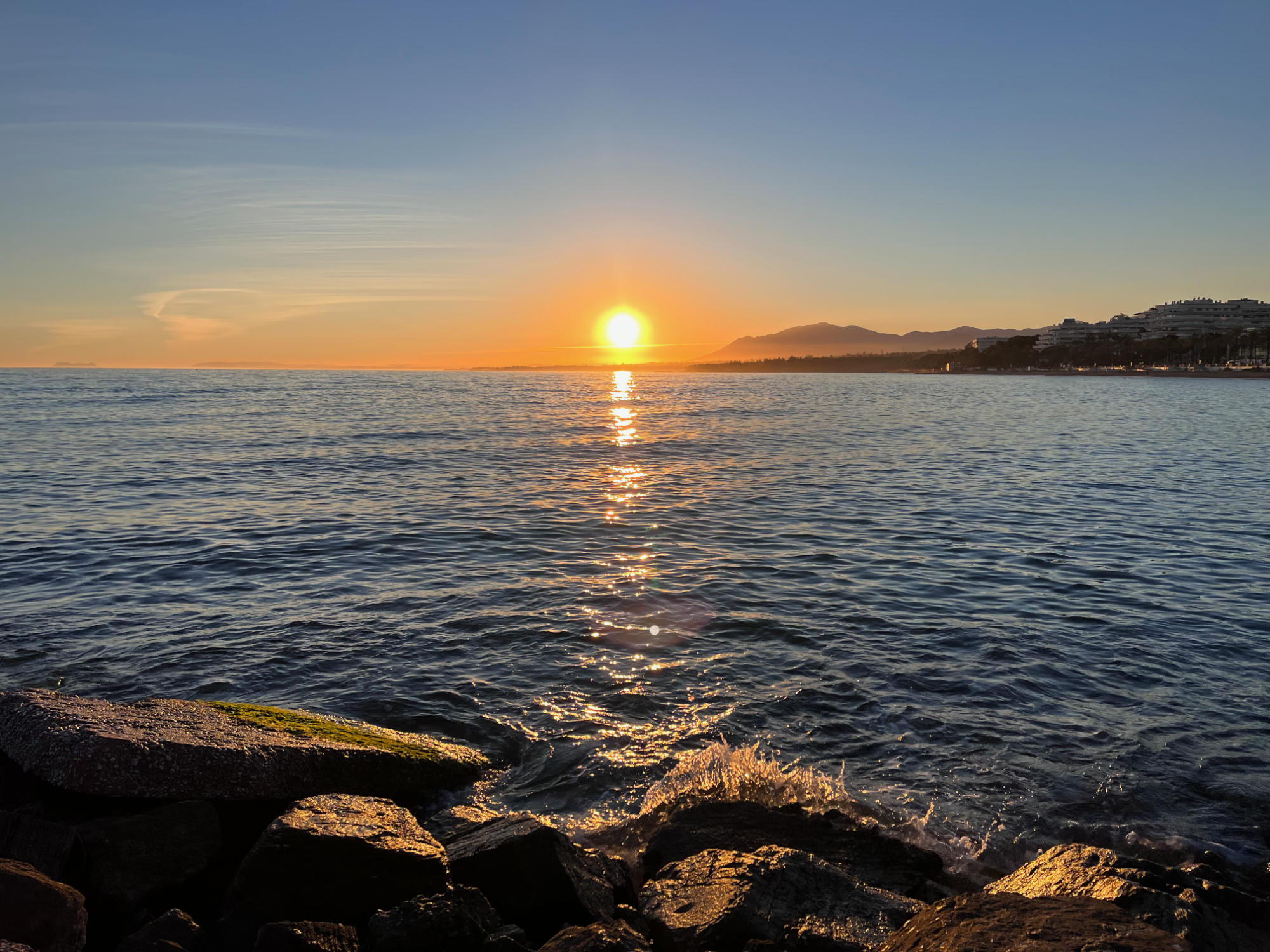 Sun setting over the mediterranean seas, shot from a rocky beach