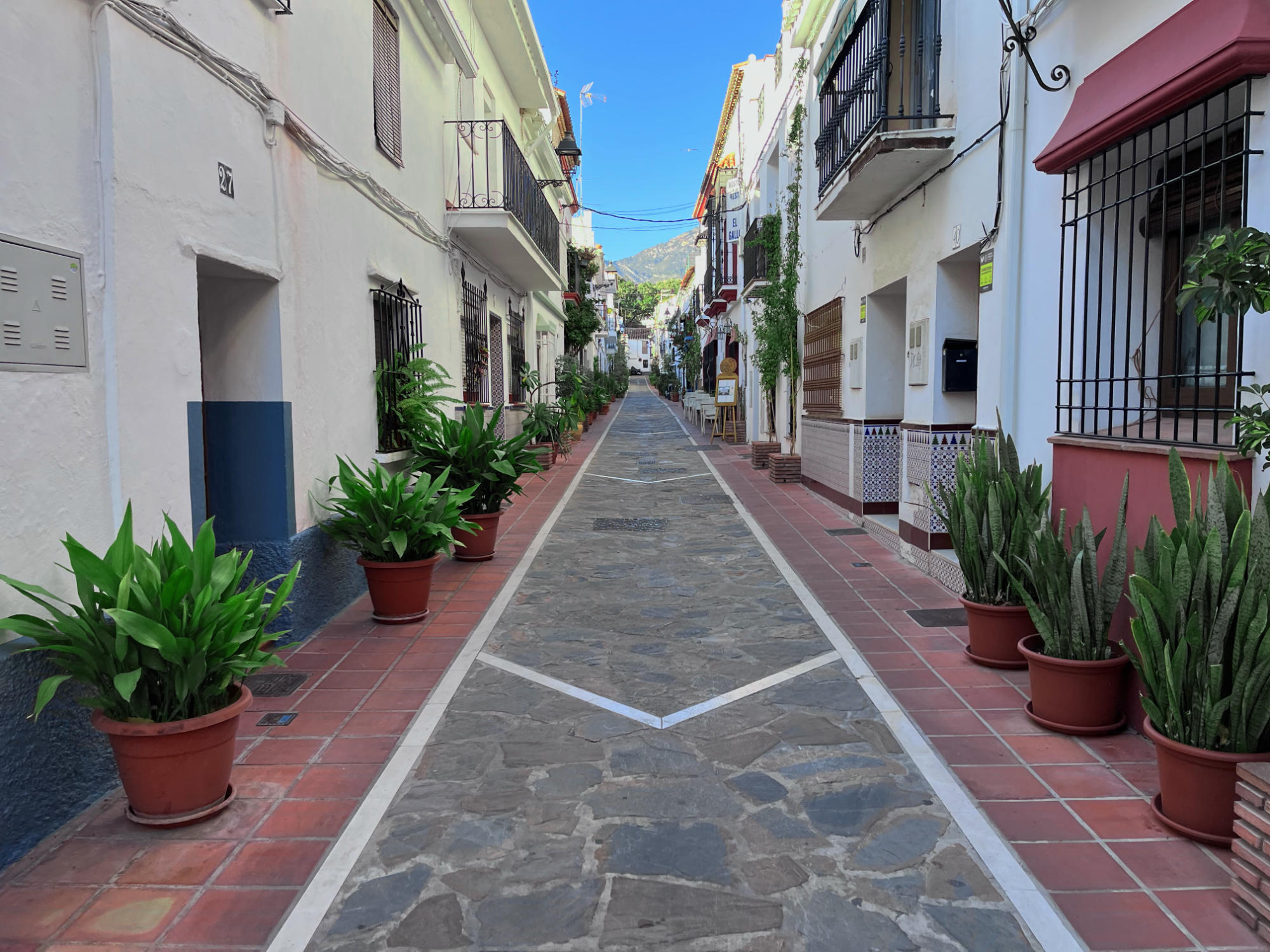 Old mediterranean street with big planters in front of every house