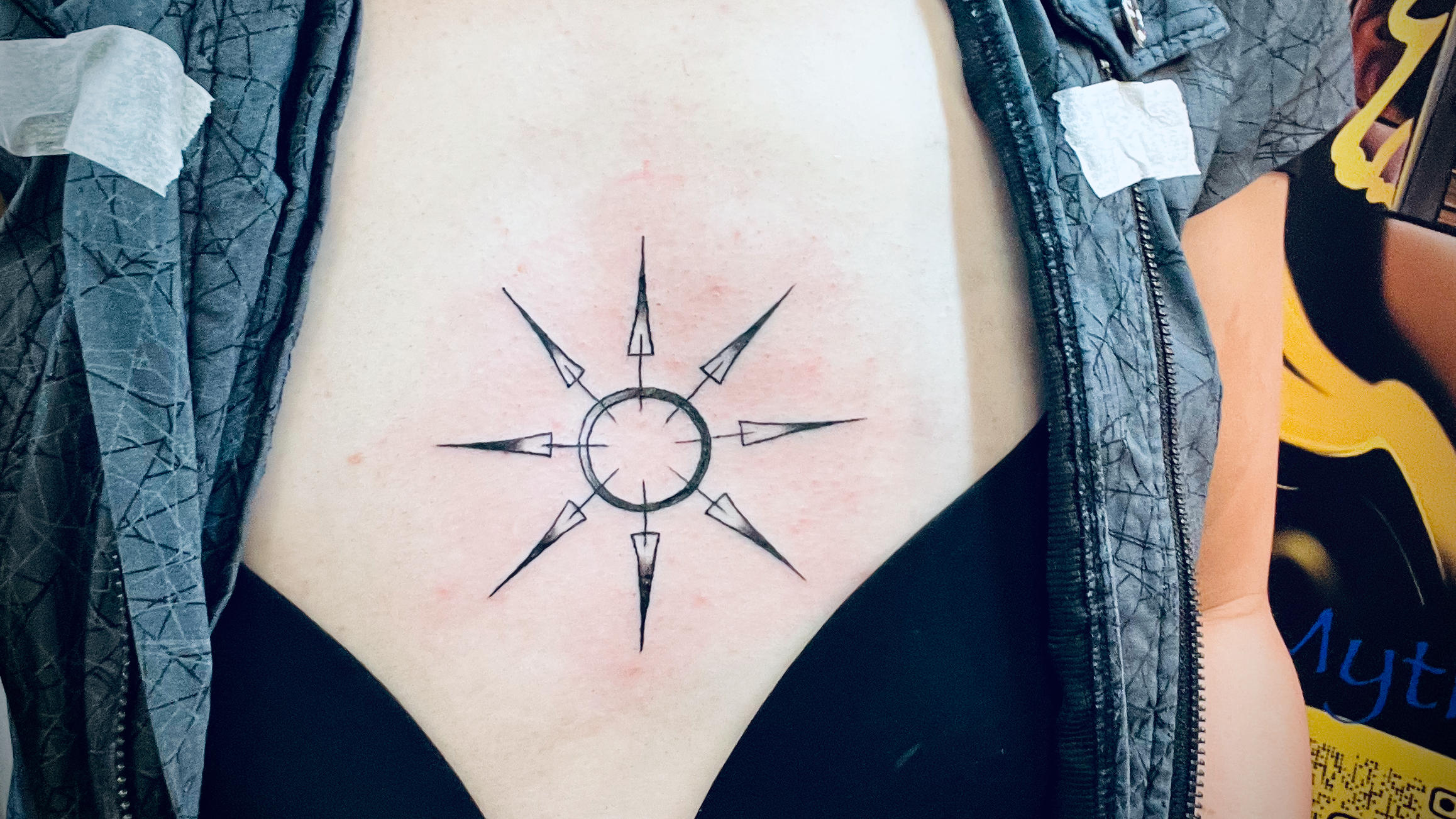 Fresh tattoo of an eight-pointed star, located on my sternum