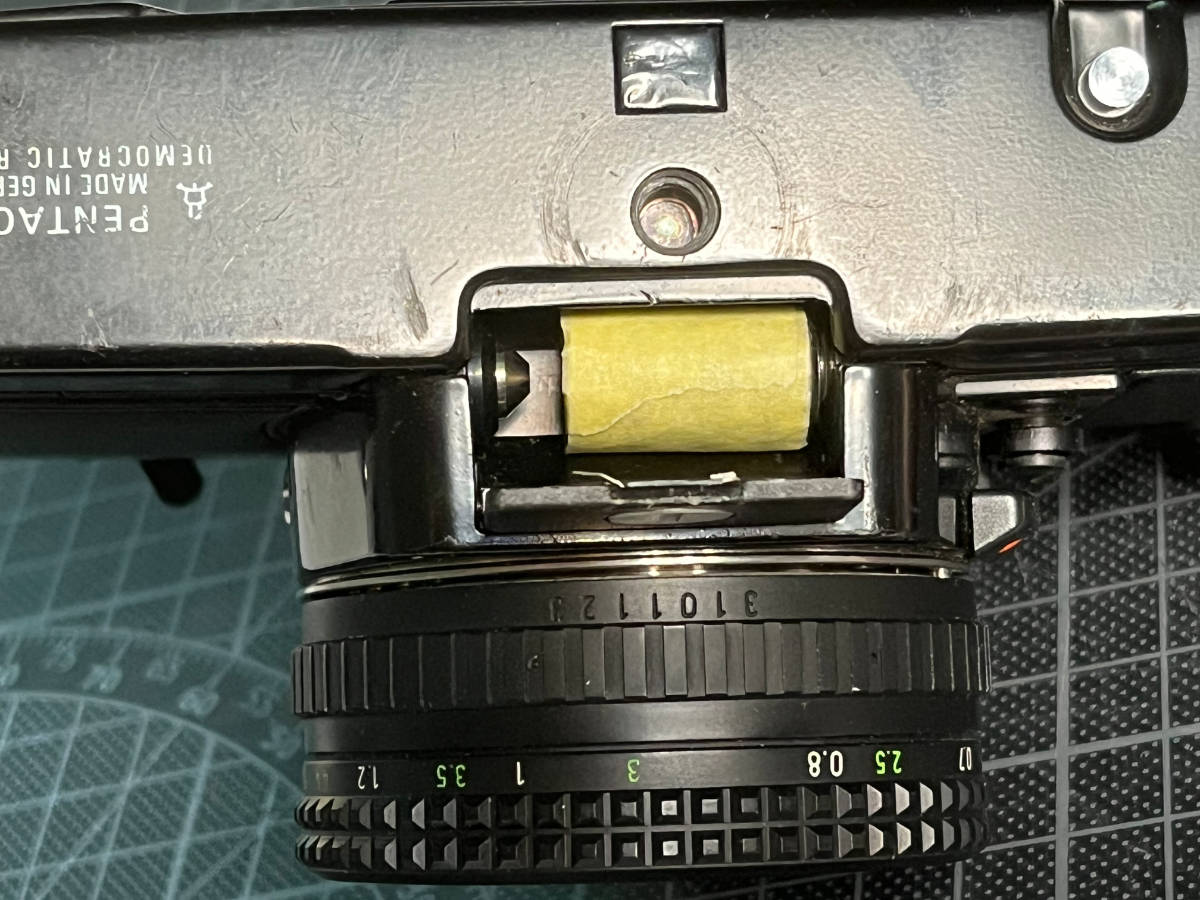 the taped stack of LR44s in the camera's battery compartment, it's a bit too short to reach both contacts